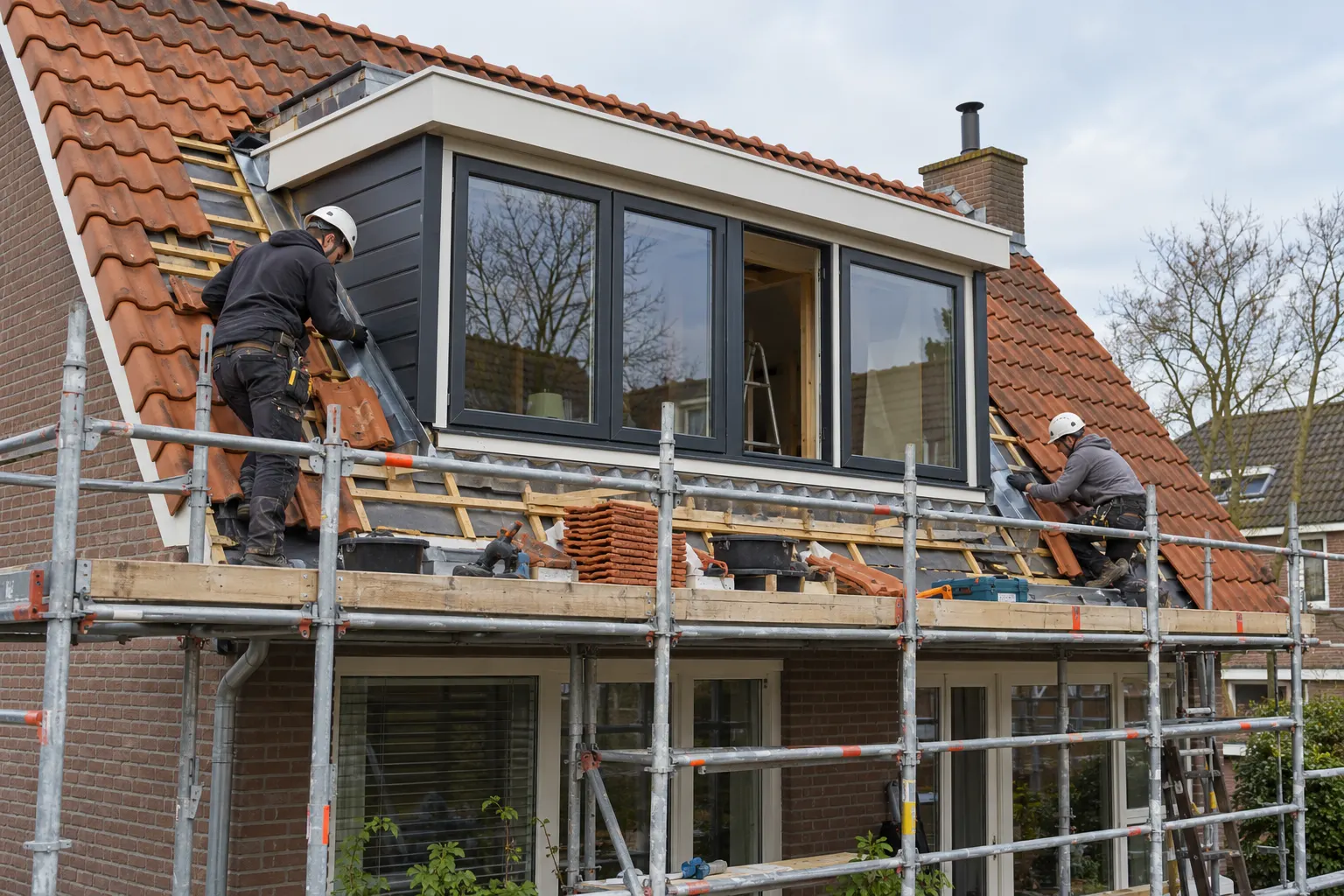 Afwerking van een dakkapel met dakpannen en loodwerk vanaf de steiger