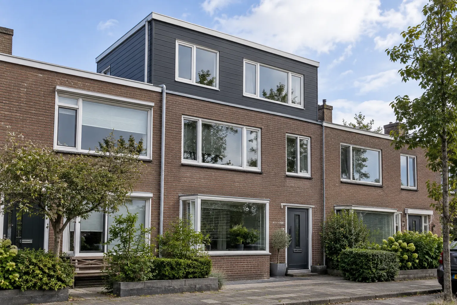 Dakopbouw in antraciet op een rijwoning, gezien vanaf de straat