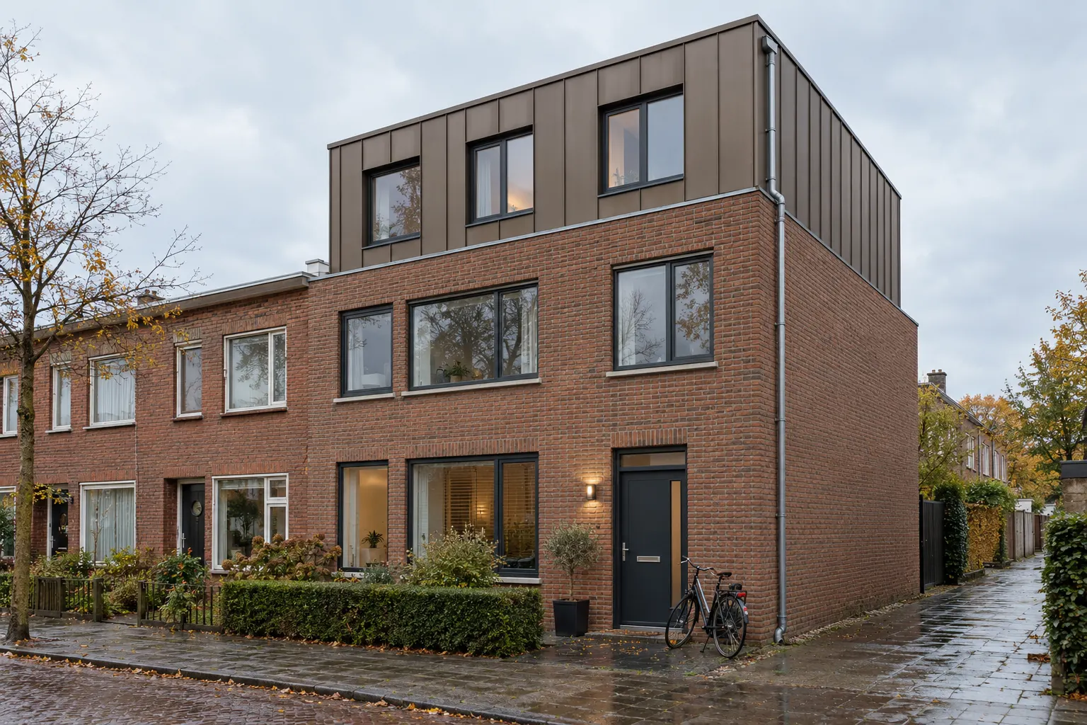Rij woningen met een nieuwe dakopbouw in antraciet zink op het hoekhuis