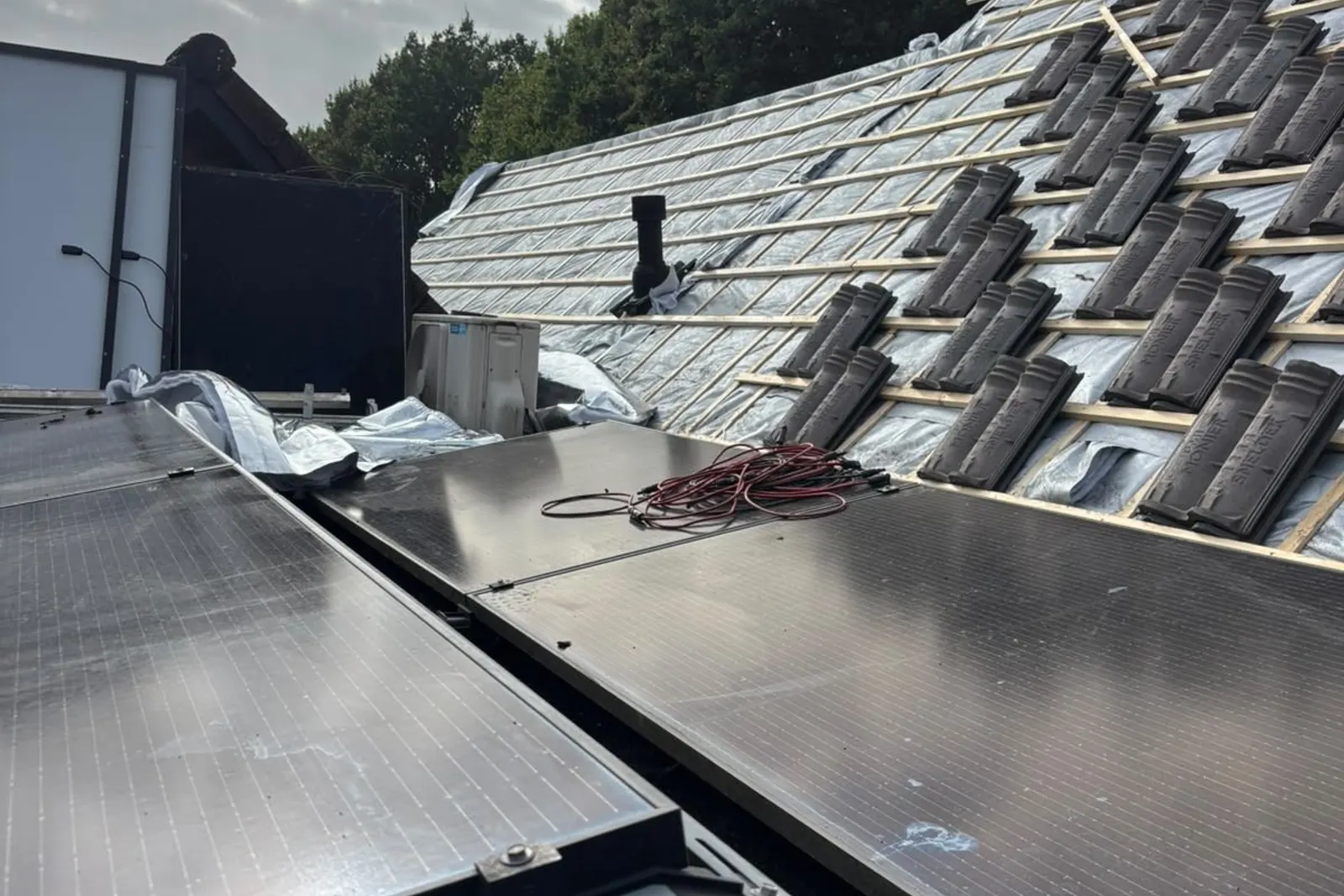 Gerenoveerd pannendak met nieuwe zonnepanelen tijdens de montage
